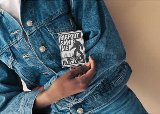 Person wearing a denim jacket with a 'Bigfoot Saw Me' patch on a beige background