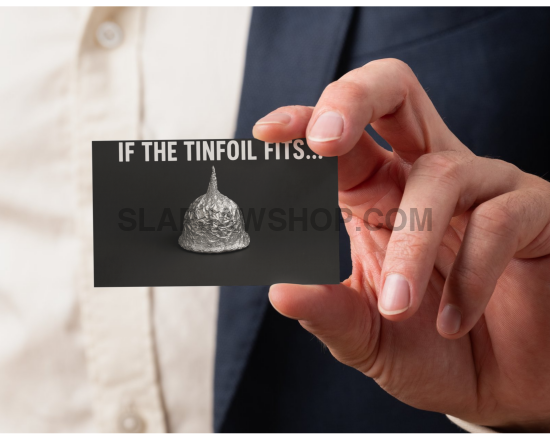 Hand holding a card with tinfoil hat and text 'IF THE TINFOIL FITS...'
