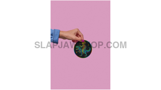 Hand holding a colorful circular object against a pink background