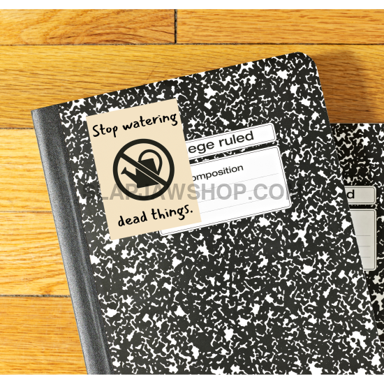 Two black and white composition notebooks on a wooden surface with a sticker on one of them.