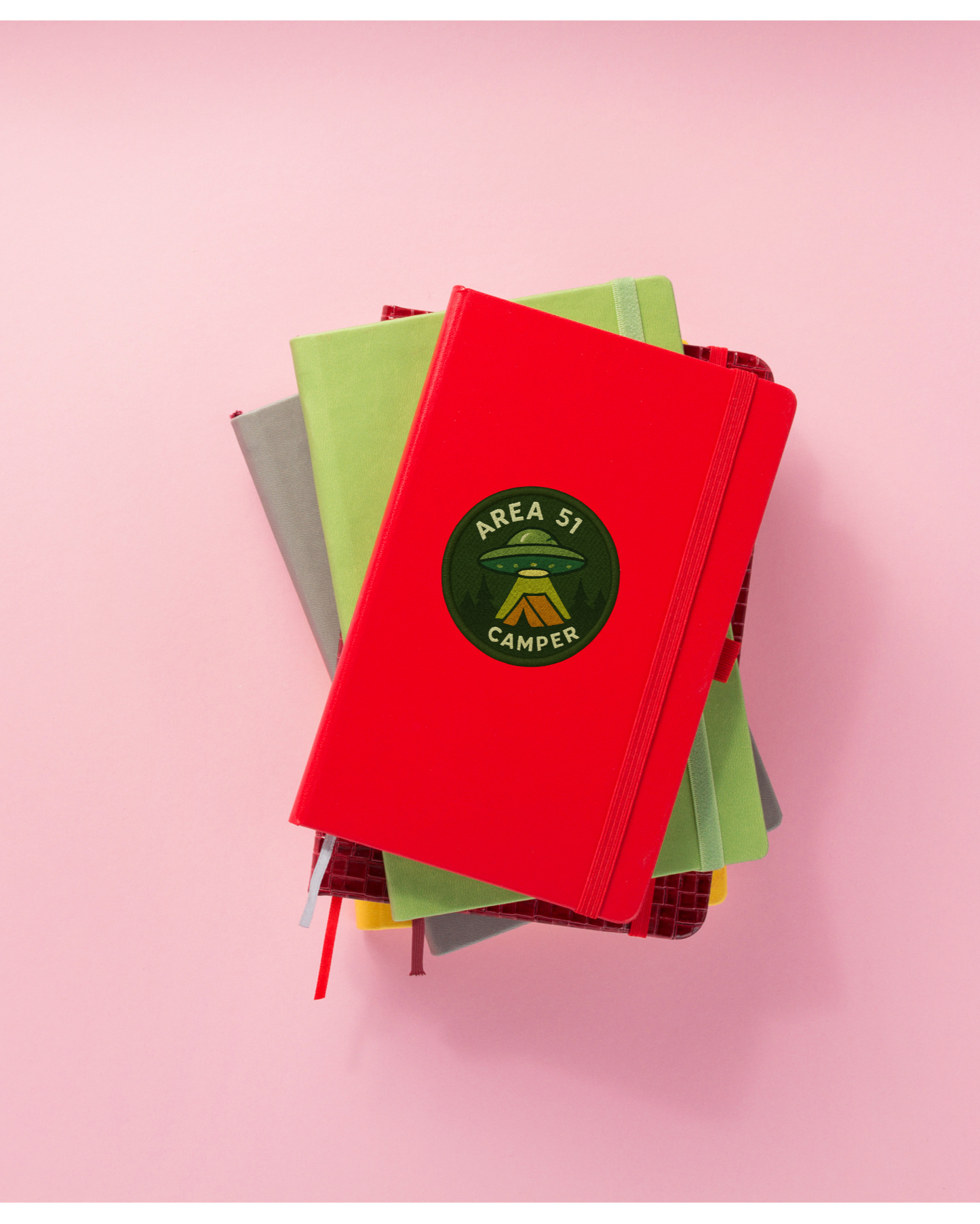Stack of colorful books with a red one on top against a pink background