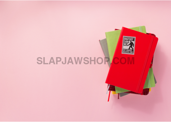 Stack of colorful notebooks on a pink background