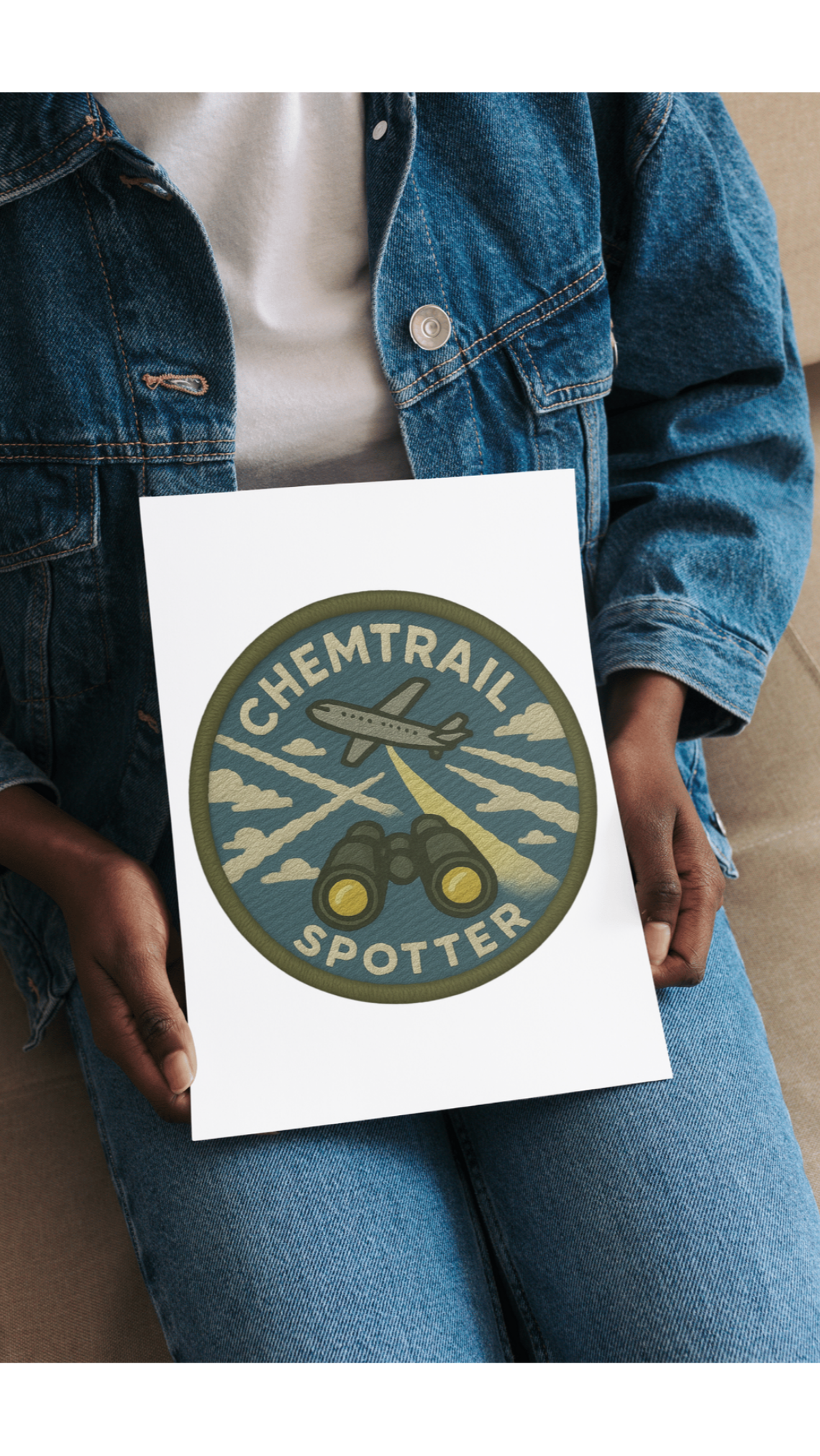 Person holding a book titled 'Chemtrail Spotter' with a logo on the cover.