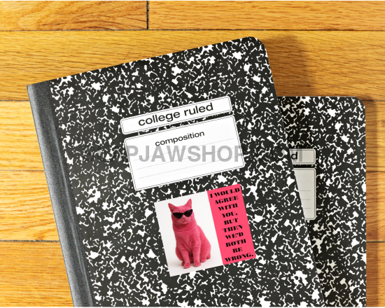 Two black and white composition notebooks with labels on a wooden surface