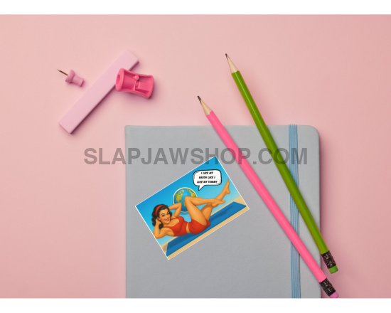 Notebook with a colorful sticker, pink and green pencils, and a pink sharpener on a pink background