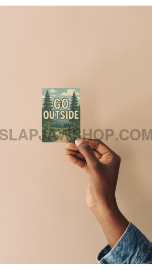 Hand holding a small green book titled 'Go Outside' against a beige background