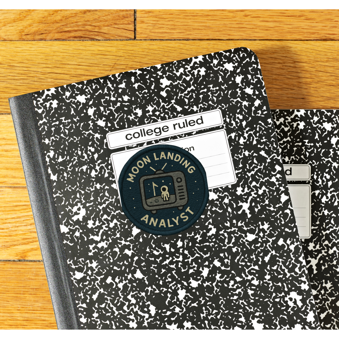 Two notebooks with 'Moon Landing Analyst' branding on a wooden surface