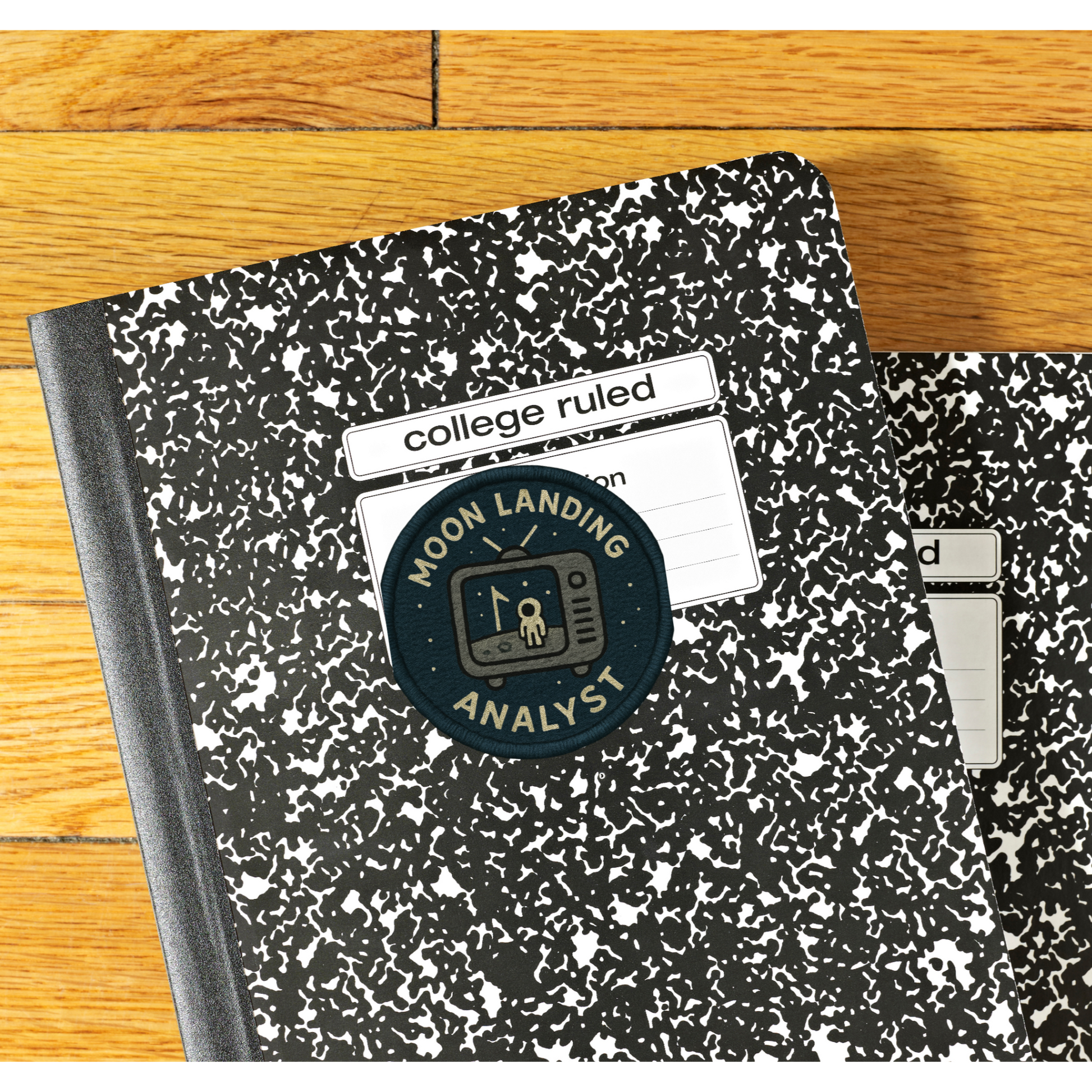 Two notebooks with 'Moon Landing Analyst' branding on a wooden surface