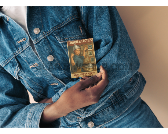 Person wearing a denim jacket holding a book titled 'Tales of the Times'.