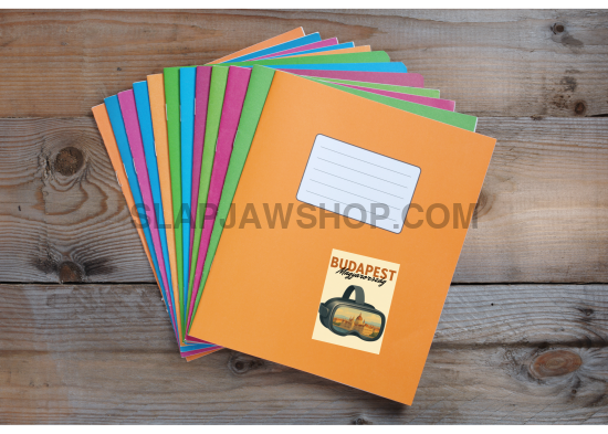 Stack of colorful notebooks with a pumpkin design on an orange notebook on a wooden surface