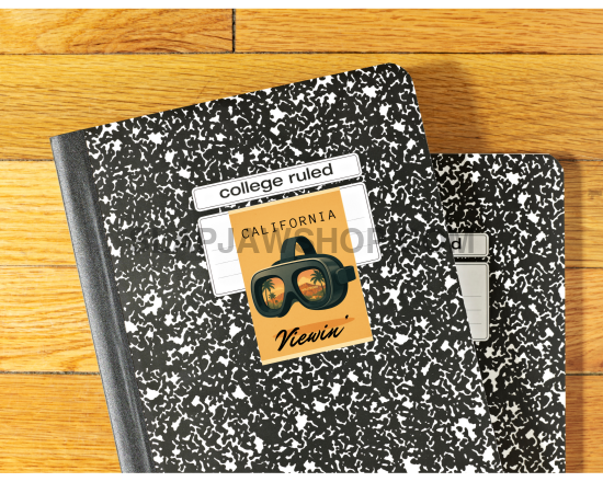 Two black and white notebooks with stickers on a wooden surface